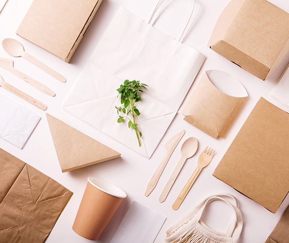 Bedruckbare Produkte wie Tüten, Besteck, Verpackungen auf einem Tisch angeordnet